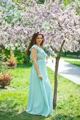 A woman in a beautiful long dress in a spring garden. Allergy free concept.