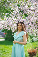 A woman in a beautiful long dress in a spring garden. Allergy free concept.