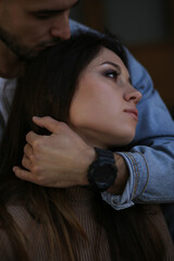 A bearded guy hugs a girl with one hand with a watch and kisses her head