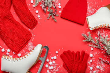 Frame made of ice skates, fir branches and warm clothes on red background