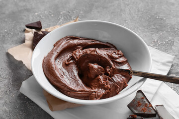 Bowl with fresh dough for preparing chocolate brownie on grey background