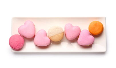 Plate with tasty heart-shaped macaroons on white background