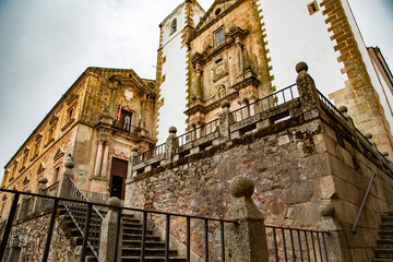 Fototapeta na wymiar Fachada y acceso a Iglesia de torres de piedra con fachada blanca en Cáceres