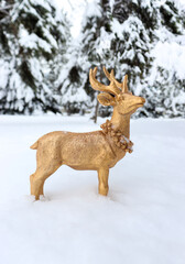 Golden deer made of wood looking for love in snowy forest
