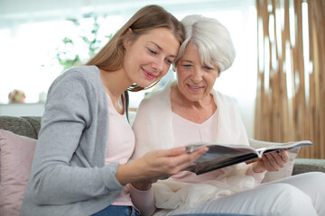 grandmother and granddaughter looking at magazine