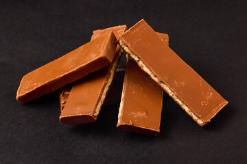 Pieces of Chocolate with caramel cream on a black background