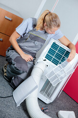 female worker working on an air conditioning unit