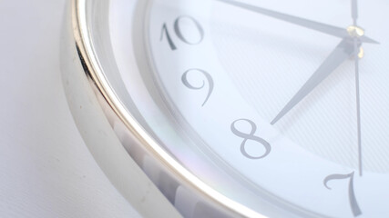 White clock face ticking. Close-up soft focus.