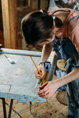 Close up view of hardworking professional carpenter woman hands working with ruler, making marks on wood. Reuse, reduce, recycle old things. Aware consumption and gender equality. Tools to repair