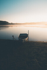 Boot im Morgennebel mit Sonnenaufgang am Anlegeplatz