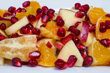 Delicious fruit salad with fresh fruit. Pomegranate, orange, apple