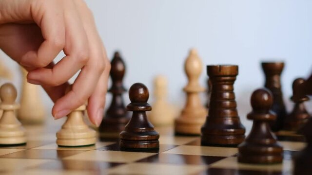 unrecognizable woman playing chess. strategy, management or leadership concept. slow motion video.