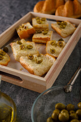 traditional baguette toasts baked with cheese, olives and olive oil. Gray background