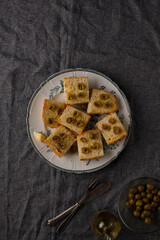 traditional baguette toasts baked with cheese, olives and olive oil. Gray background
