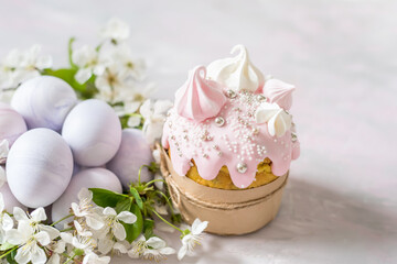 Fototapeta na wymiar Easter still life. Traditional pastries, painted eggs and white cherry flowers on a light delicate background.