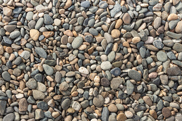 Beautiful texture of colorful smooth stones is on the beach by sea