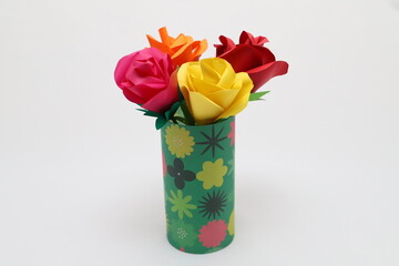 折り紙で作ったバラの花をカラフルなグラスに飾った様子