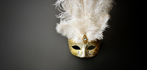 A beautiful Venetian carnival mask. Gold and white. Glow, mystery, dark background