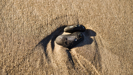 Fototapeta na wymiar heart-shaped stone in the sand of the beach on the Baltic Sea