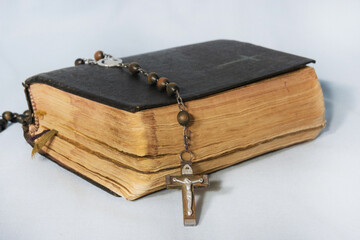 Black tattered Bible and Holy Rosary. The concept of Christian faith