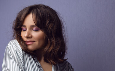 Portrait of a beautiful young woman with lilac makeup