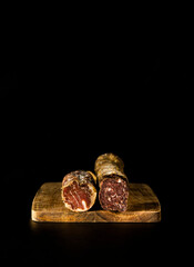 Still life of Spanish Iberian cured meats against black background