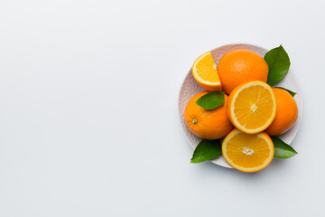 Flat lay of Fresh orange fruit with sliced in plate on Colored background. Top view with copy space