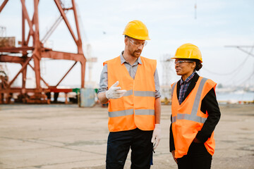 Multiracial man and woman talking while working at port
