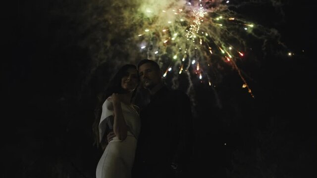 beautiful couple in love at the fireworks in the evening