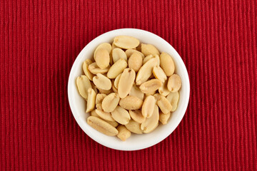 Salted Peanuts in Bowl on red textured cloth