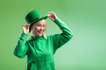 St. Patrick's Day. Beautiful smiling woman wearing green hat. Green background