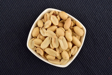 Bowl of Peeled Peanuts on Blue Textured Cloth
