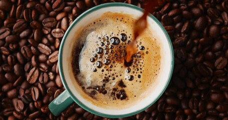 brewed coffee in a geyser coffee maker is poured into a coffee mug, top view, slow motion - Powered by Adobe