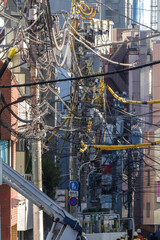 1本の路地に複数の工事現場がある。電線は絡み合うかのように道路の上を占拠している。東京赤坂5丁目の街の風景