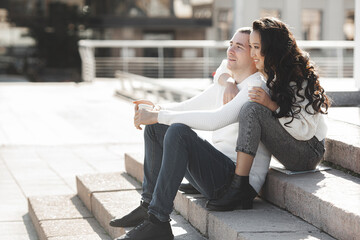 Adorable multiracial couple outdoors. Young people have a date. Woman and man happy together.