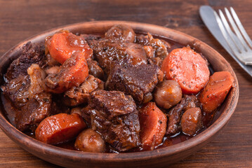 Burgundy Beef close-up in a plate - a traditional French dish of beef, mushrooms, carrots and onions with red wine