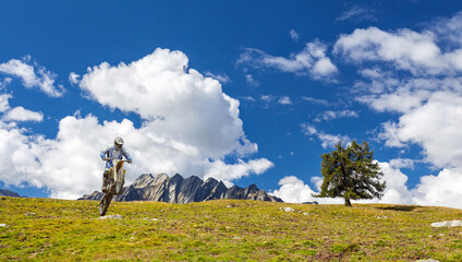 jump with motocross bike in summer alpine landscape