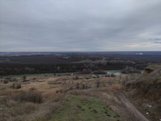 Winter landscape, hill, river, trees, fields, clouds and mole holes