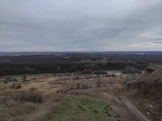 Winter landscape, hill, river, trees, fields, clouds and mole holes