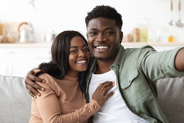 Fototapeta premium Cheerful african american man and woman taking photo together