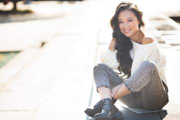 Beautiful woman outdoors. Pretty lady on urban background. Asian female closeup portrait.