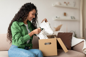 Happy Female Buyer Holding Footwear Unpacking Cardboard Box At Home - obrazy, fototapety, plakaty