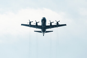 Huge military transport plane or bomber with propellers view from below. The concept of air clashes...