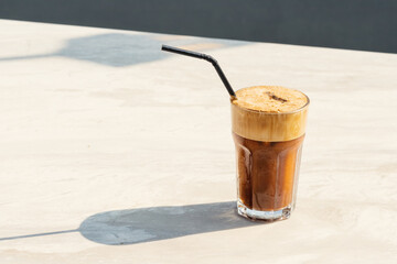 Sweet and strong frappe coffee with abundant foam in a simple glass