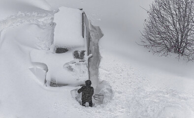 a man digs his car out of the snow captivity.