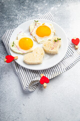 valentines day egg fried breakfast on the table scrambled eggs heart shape holiday decoration love date copy space food background