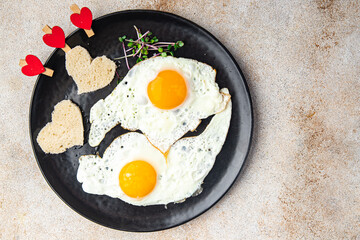 valentines day egg fried breakfast on the table scrambled eggs heart shape holiday decoration love date copy space food background