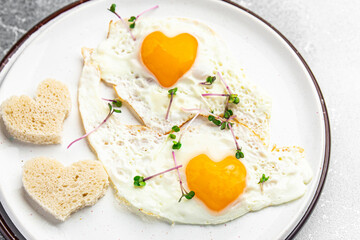 valentines day egg fried breakfast on the table scrambled eggs heart shape holiday decoration love date copy space food background