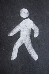 Close-up of a traffic marking in the shape of a pedestrian painted on the asphalt