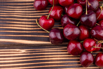 Sweet and ripe red cherry on wooden background. Summer fruit close up image with copy space.